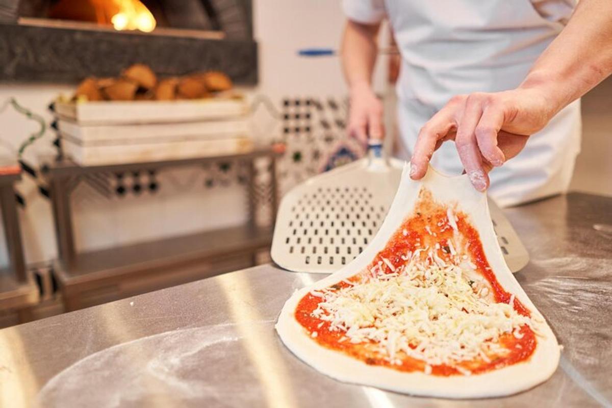 en person tilbereder en pizza på en bordplade