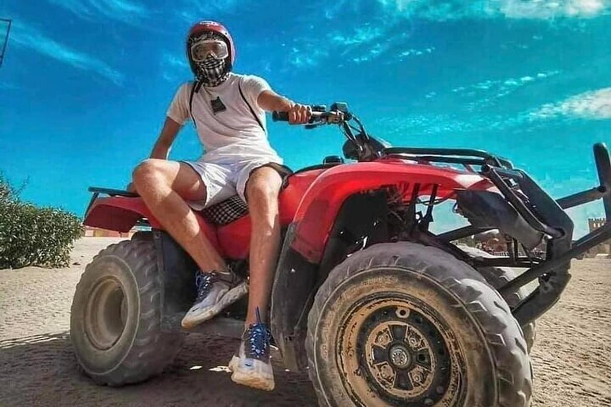 um homem sentado em cima de um quadriciclo vermelho