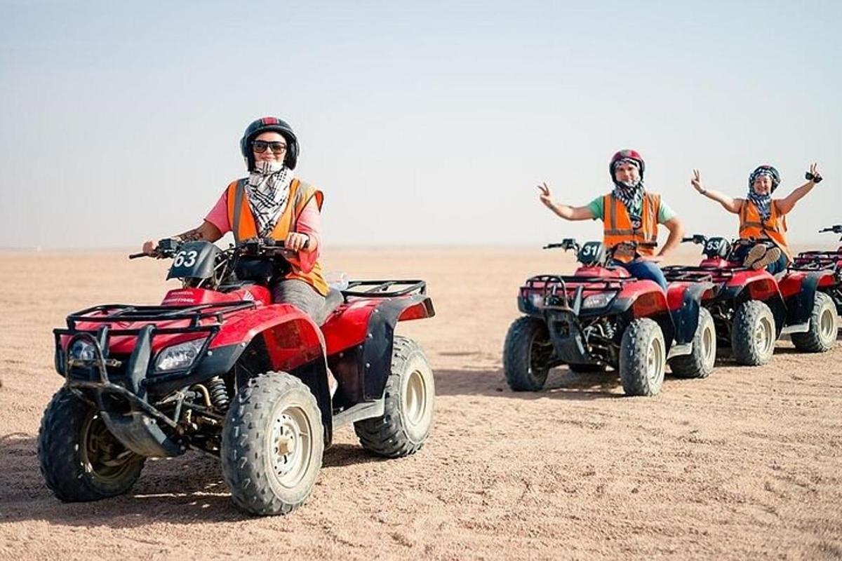 um grupo de pessoas andando de quadriciclo no deserto