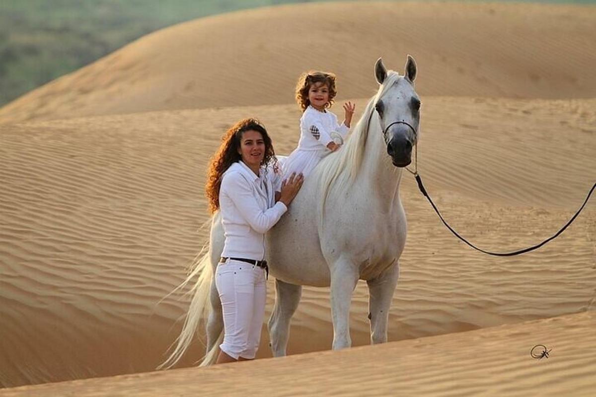 uma mulher e uma menina cavalgando no deserto