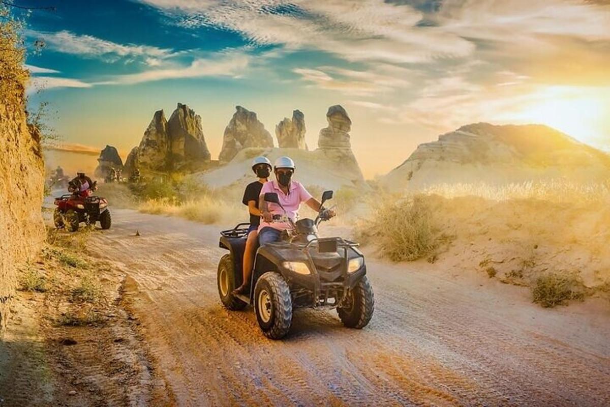due persone che guidano un quad su una strada sterrata