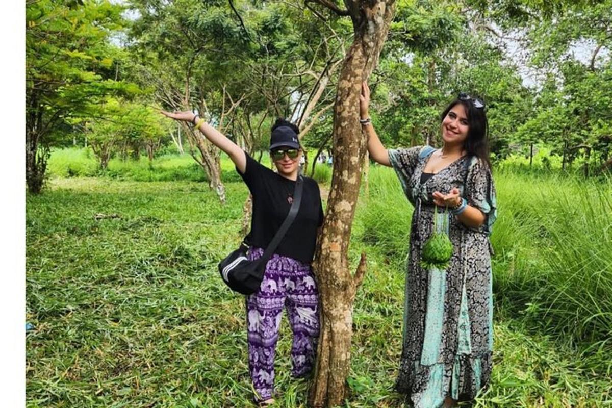 due donne sono in piedi accanto a un albero