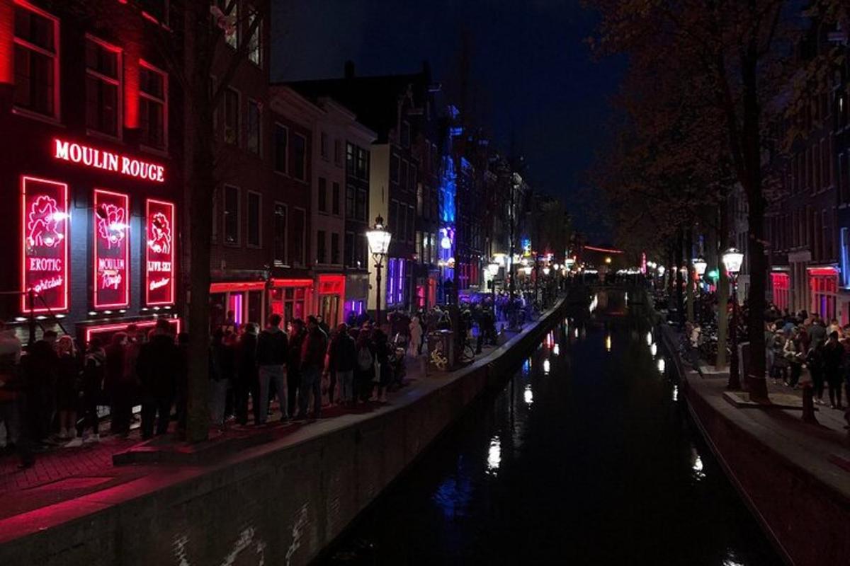 een groep mensen die 's nachts langs een kanaal staat