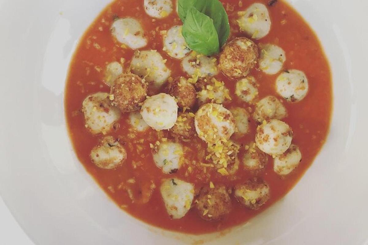 uma tigela de sopa com almôndegas e molho de tomate
