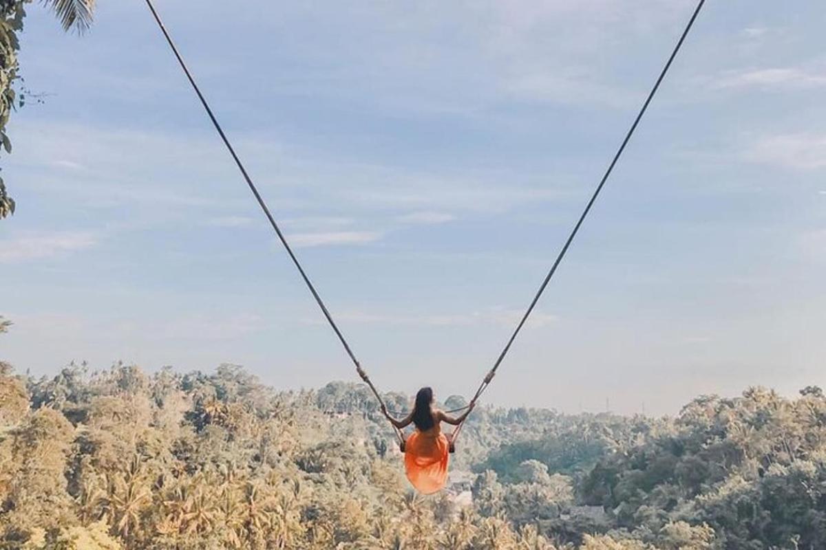 ženska v oranžni obleki visi na ziplineu