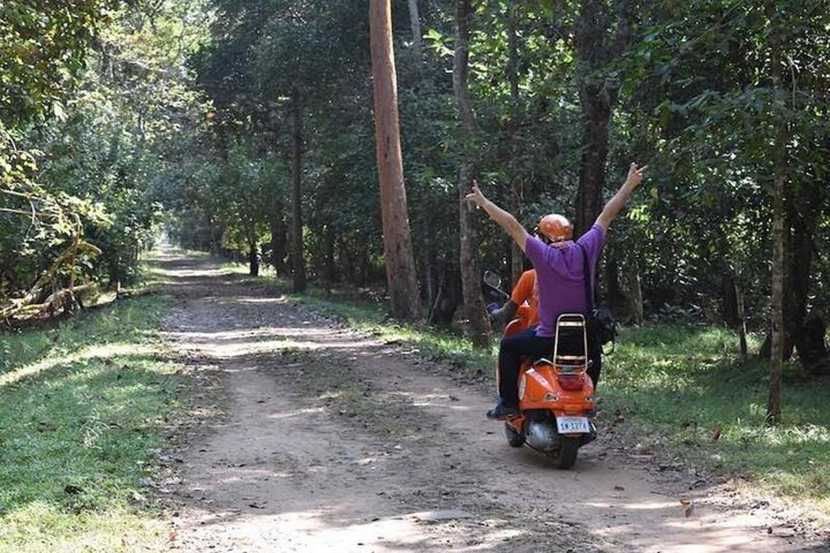 toprak yolda motorlu scooter kullanan bir kişi