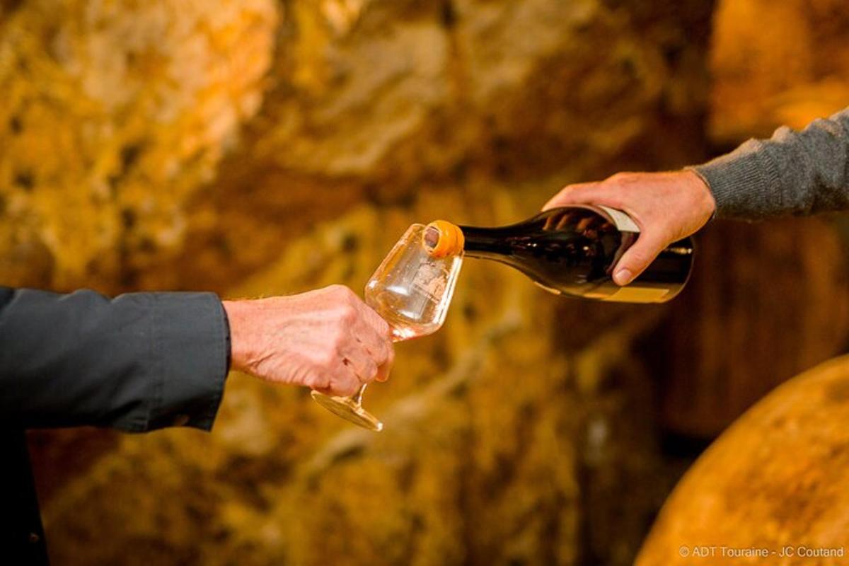 two people holding a bottle of wine in their hands