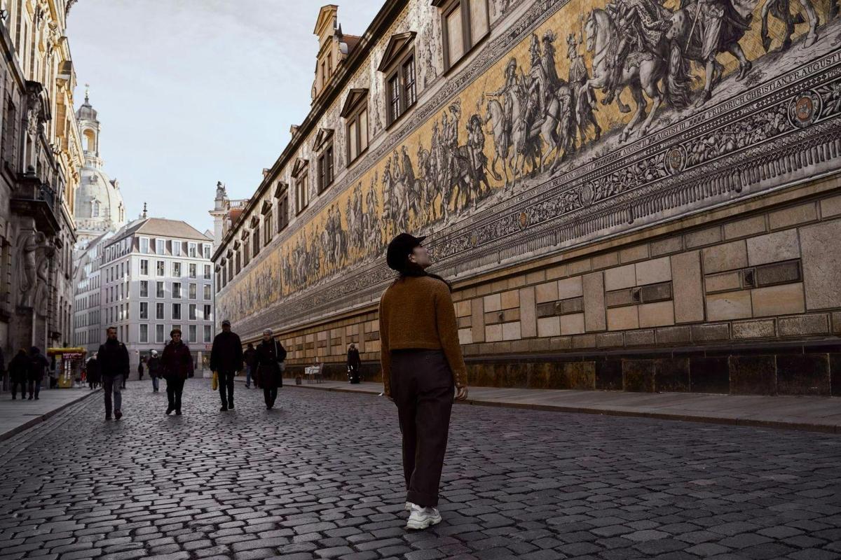 una donna che cammina lungo una strada accanto a un edificio