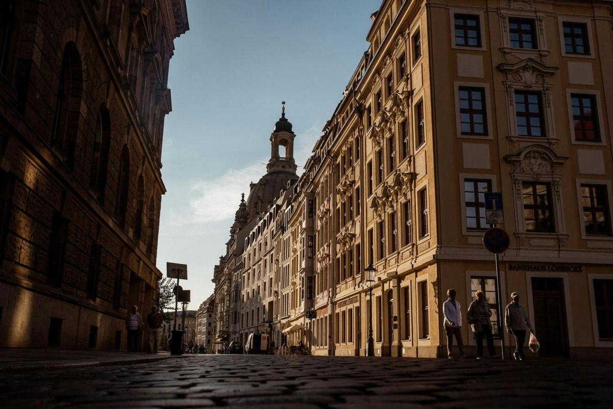 due persone in piedi su una strada in una città con edifici