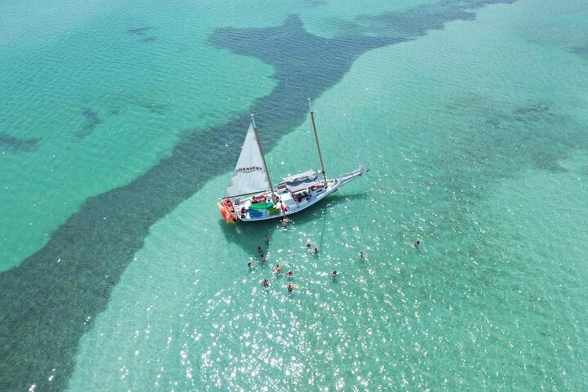 loď v oceánu s lidmi ve vodě