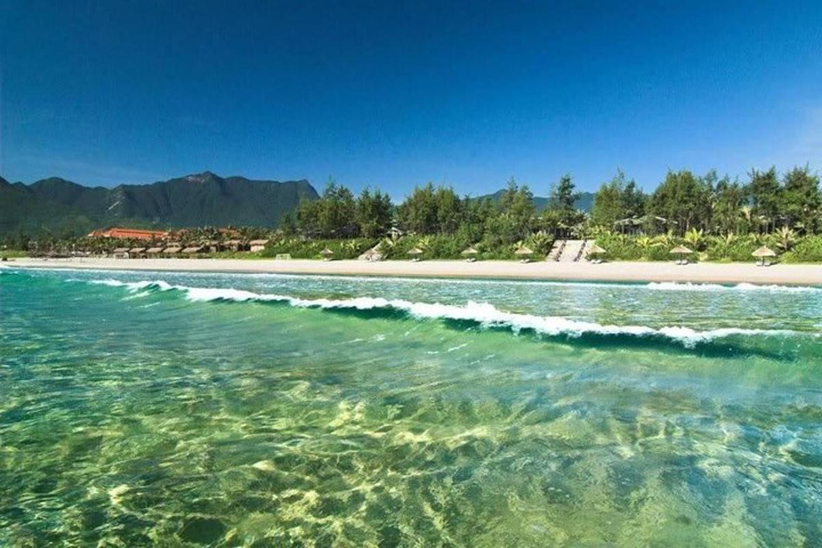 водойма з пляжем, деревами та горами