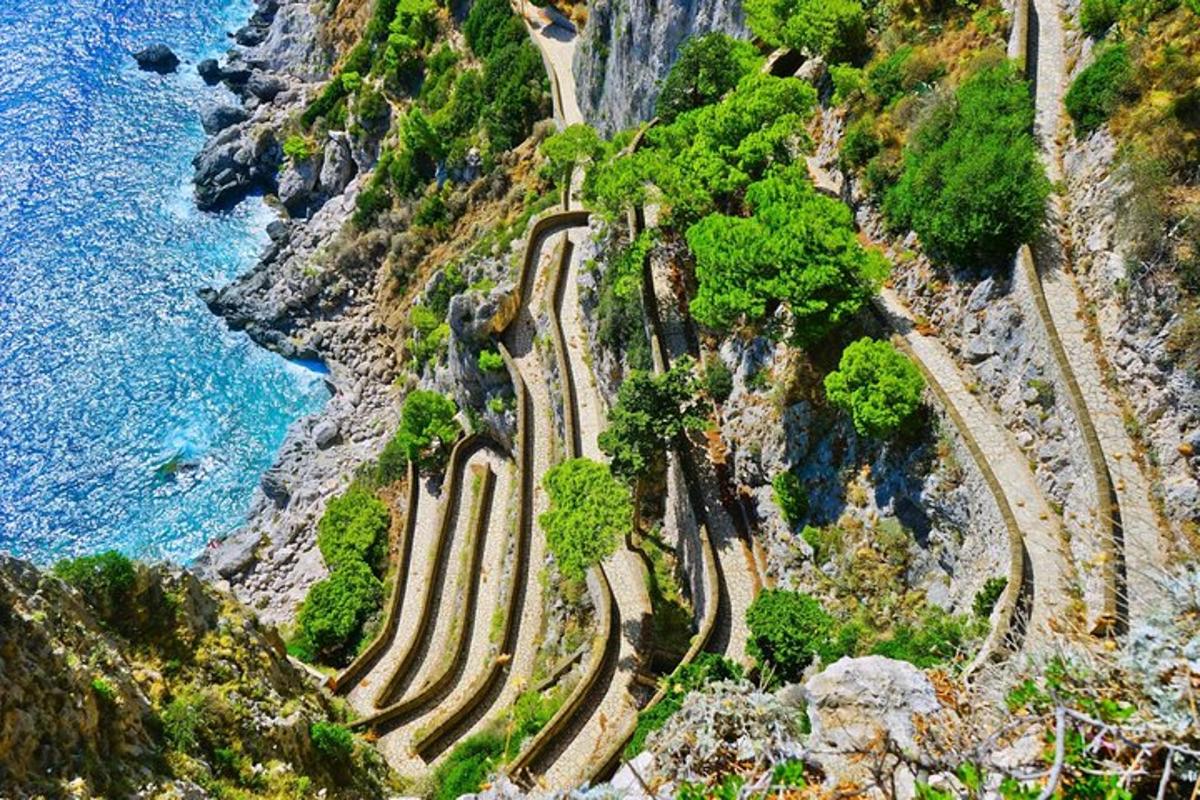 una carretera sinuosa al vessant d'una muntanya al costat de l'oceà
