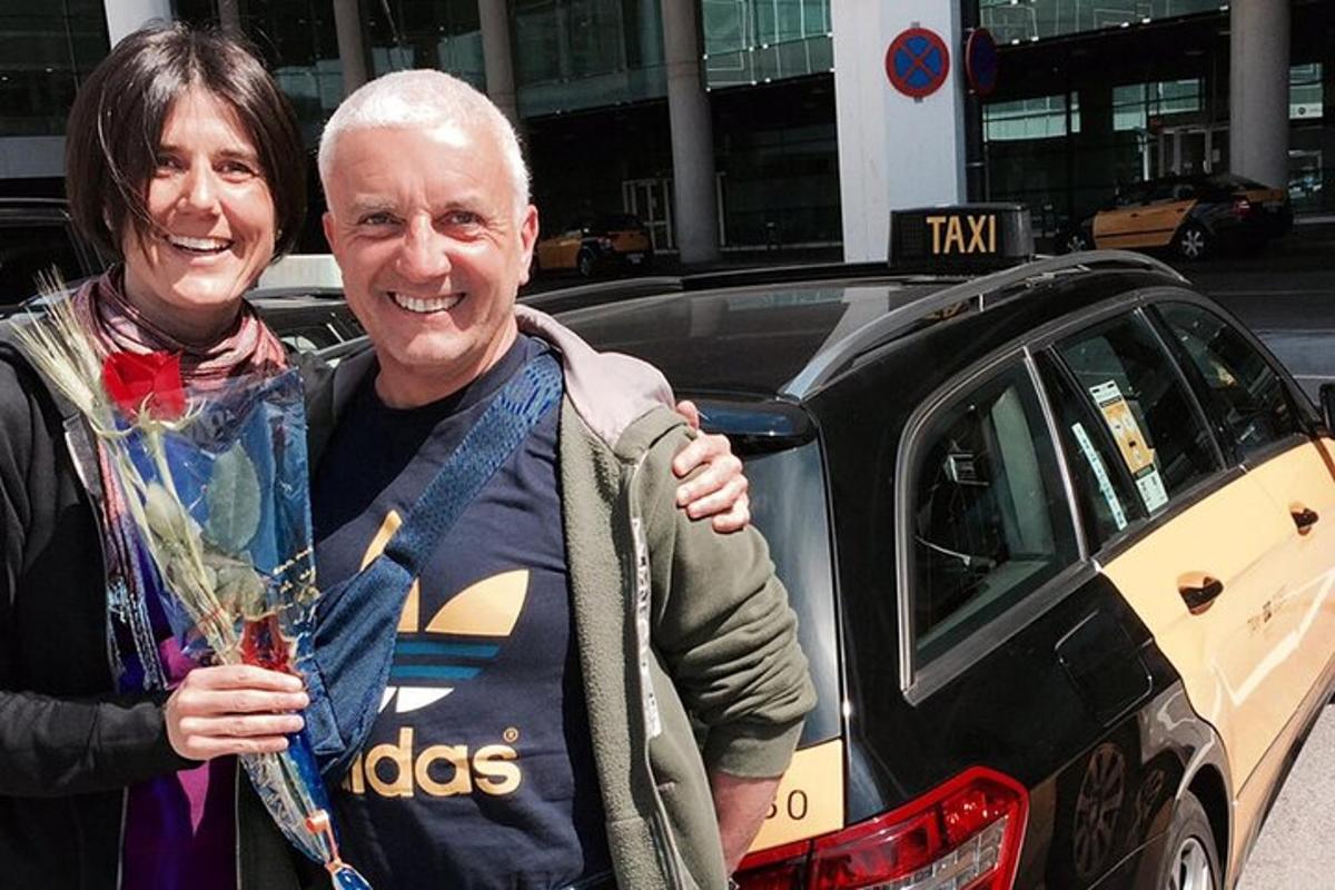 um homem e uma mulher parados na frente de um táxi