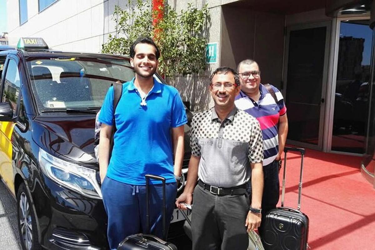 μια ομάδα τριών ανδρών που στέκονται δίπλα σε ένα αυτοκίνητο