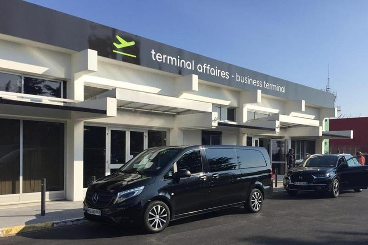 črn kombi parkiran pred prodajalno avtomobilov