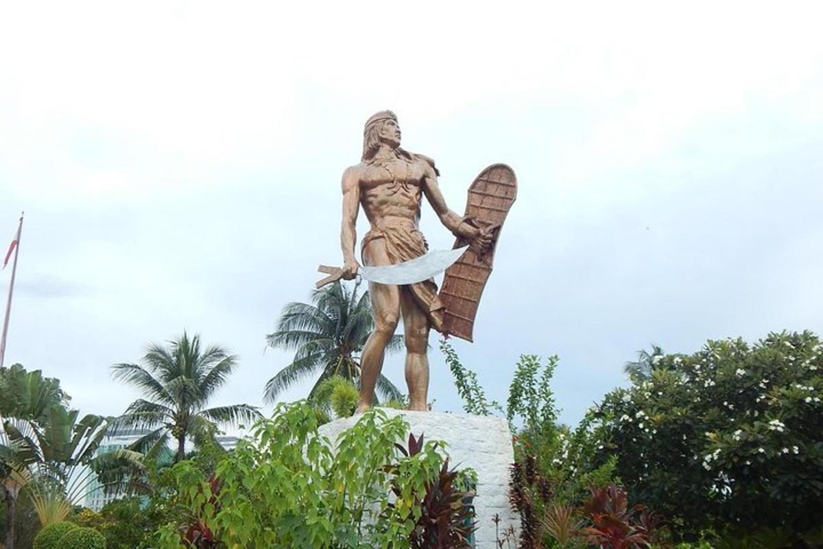 o statuie a unui bărbat care ține o placă de surf