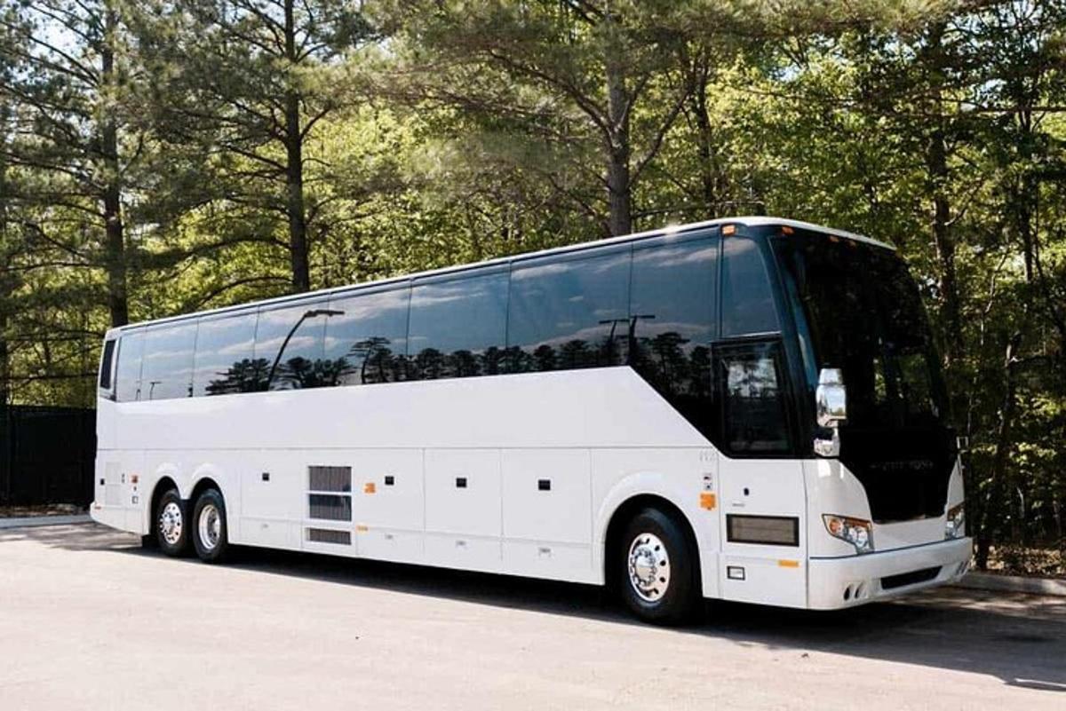 duży biały autobus zaparkowany na parkingu