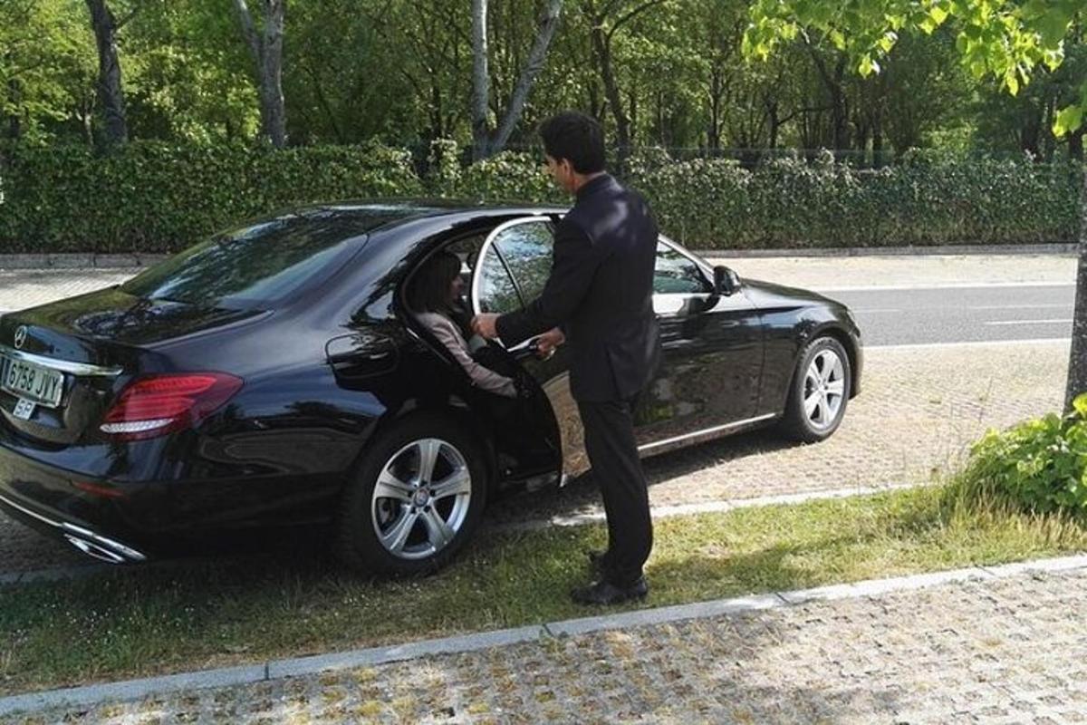 ein Mann steht neben einem schwarzen Auto