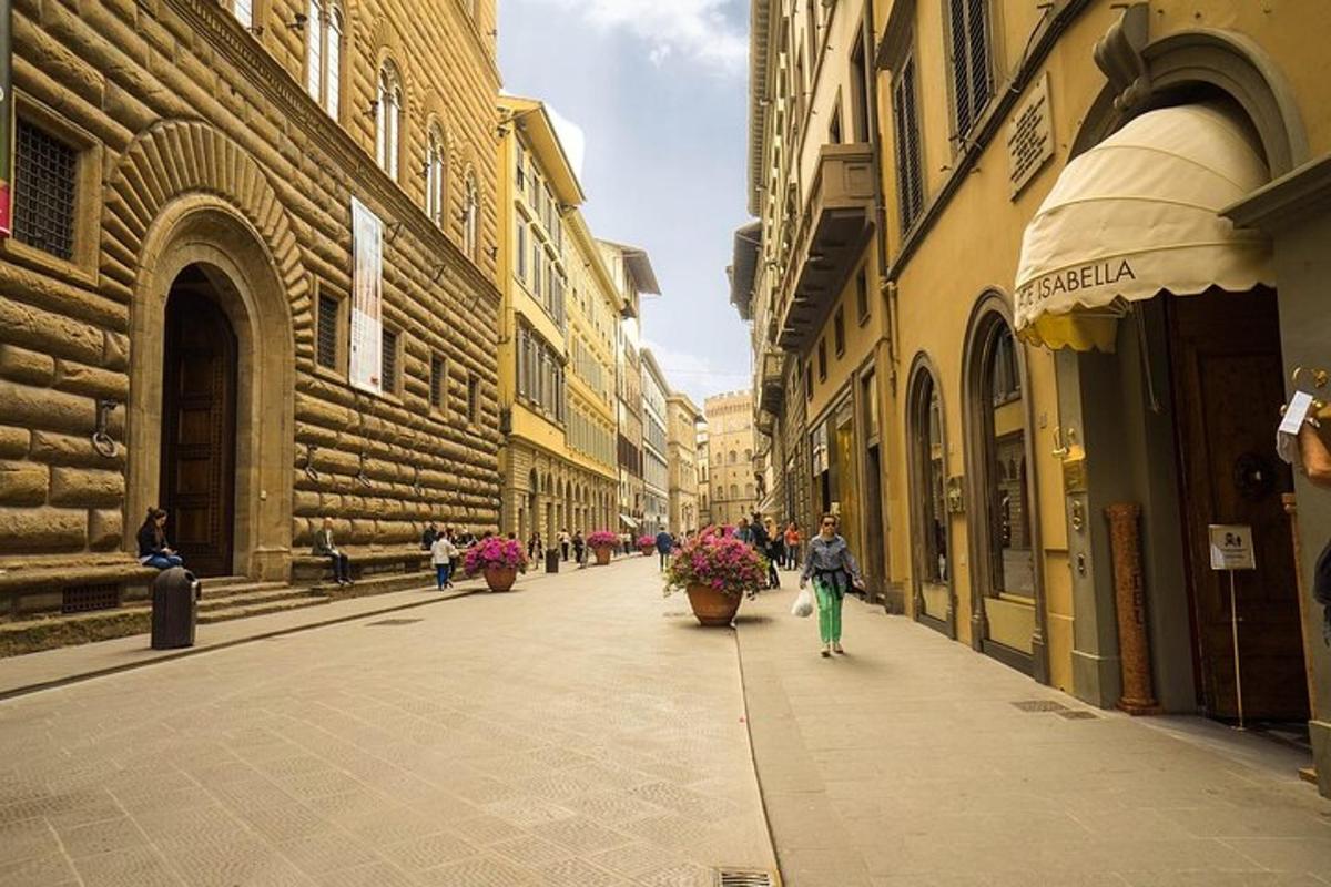 člověk jdoucí po ulici s květinami v květináčích