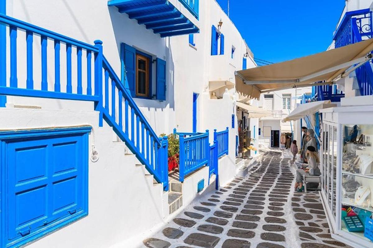 un carrer estret amb portes blaves sobre edificis blancs