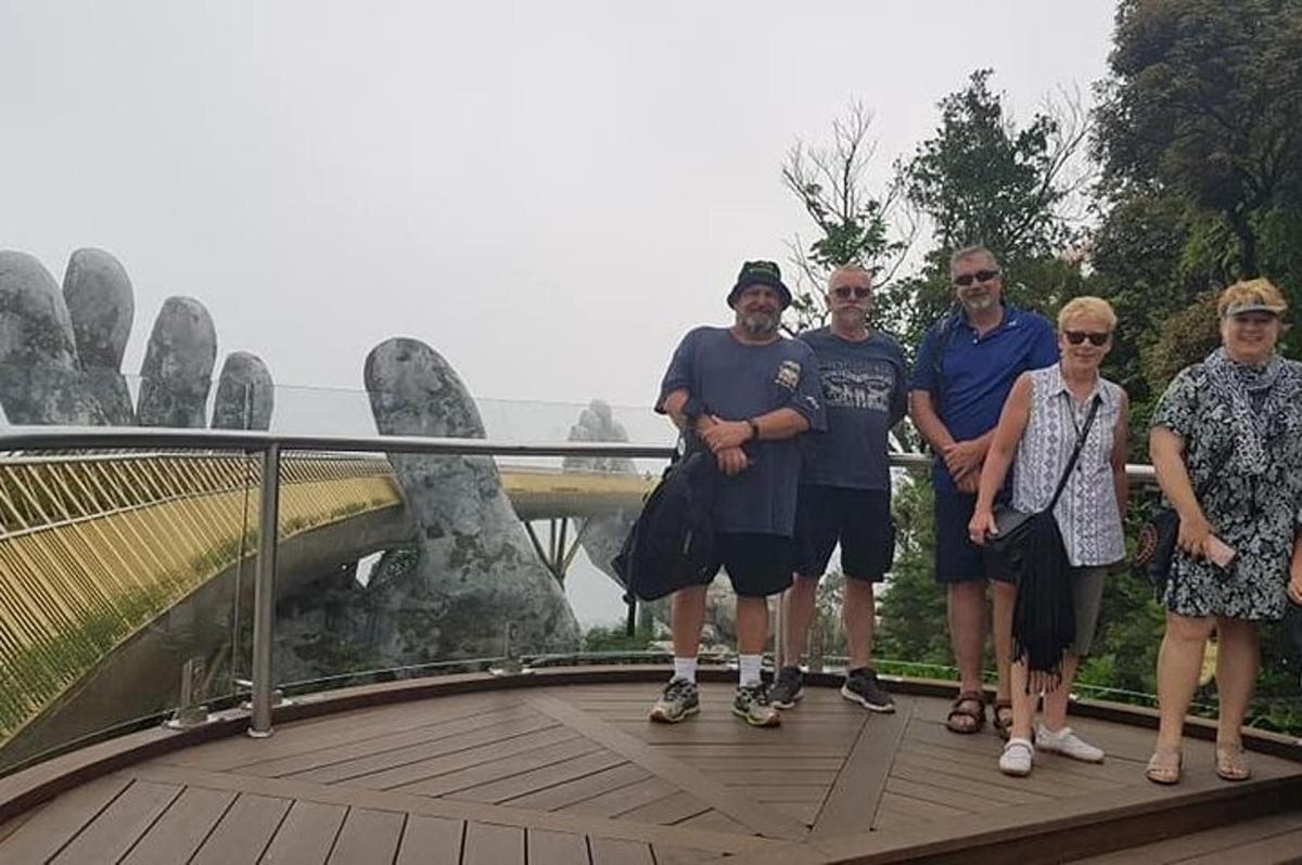 skupina lidí pózujících pro fotografii na mostě
