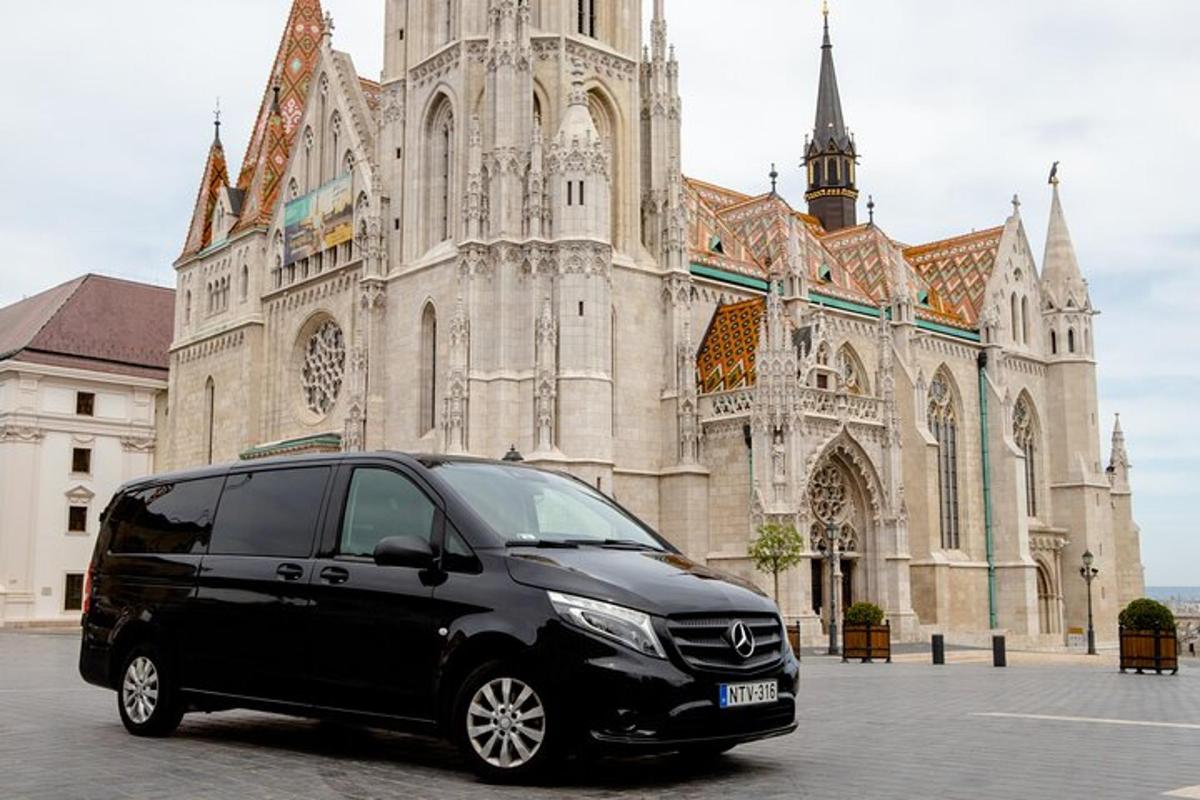 uma van preta estacionada em frente a uma igreja