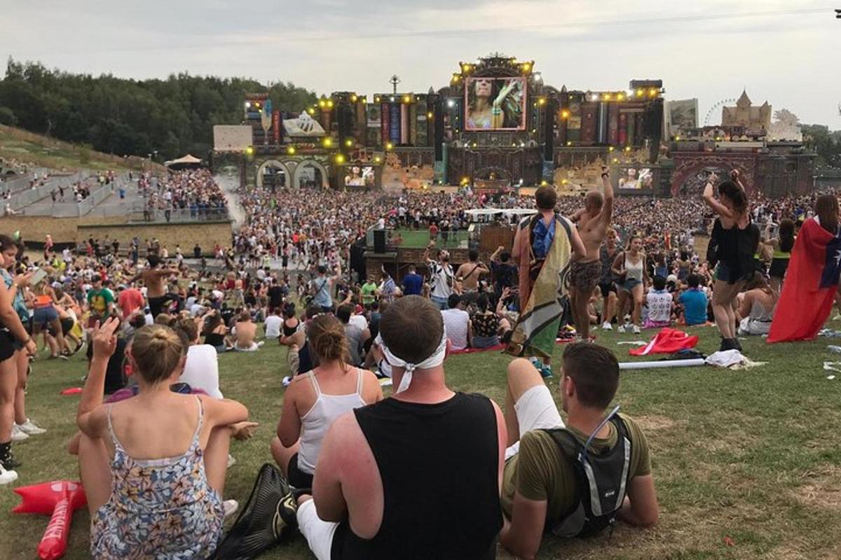 a large crowd of people sitting on the grass at a concert