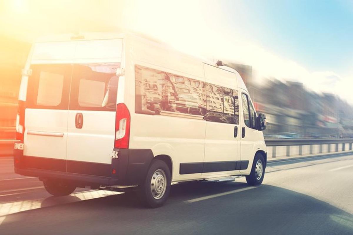 valkoinen pakettiauto ajaa kadulla