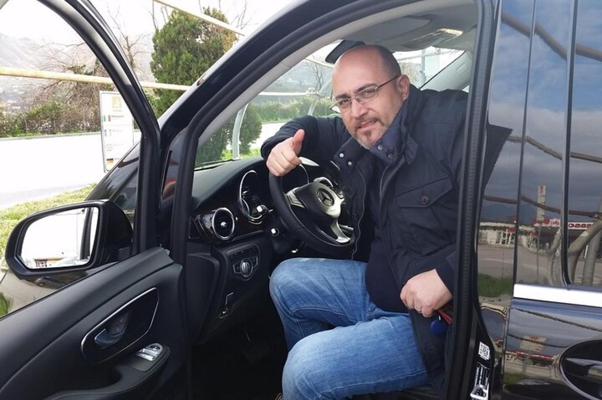 un uomo seduto in macchina con in mano una macchina fotografica