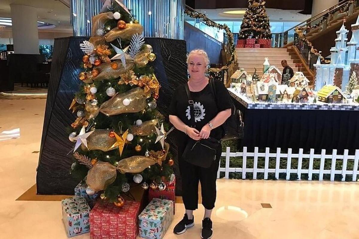 Una mujer parada junto a un árbol de Navidad en una tienda.