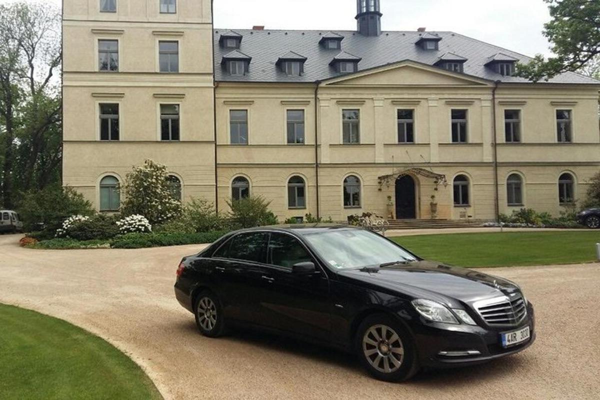 черная машина, припаркованная перед большим домом