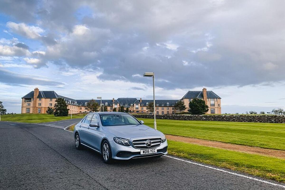 a silver car parked on a road in front of a building