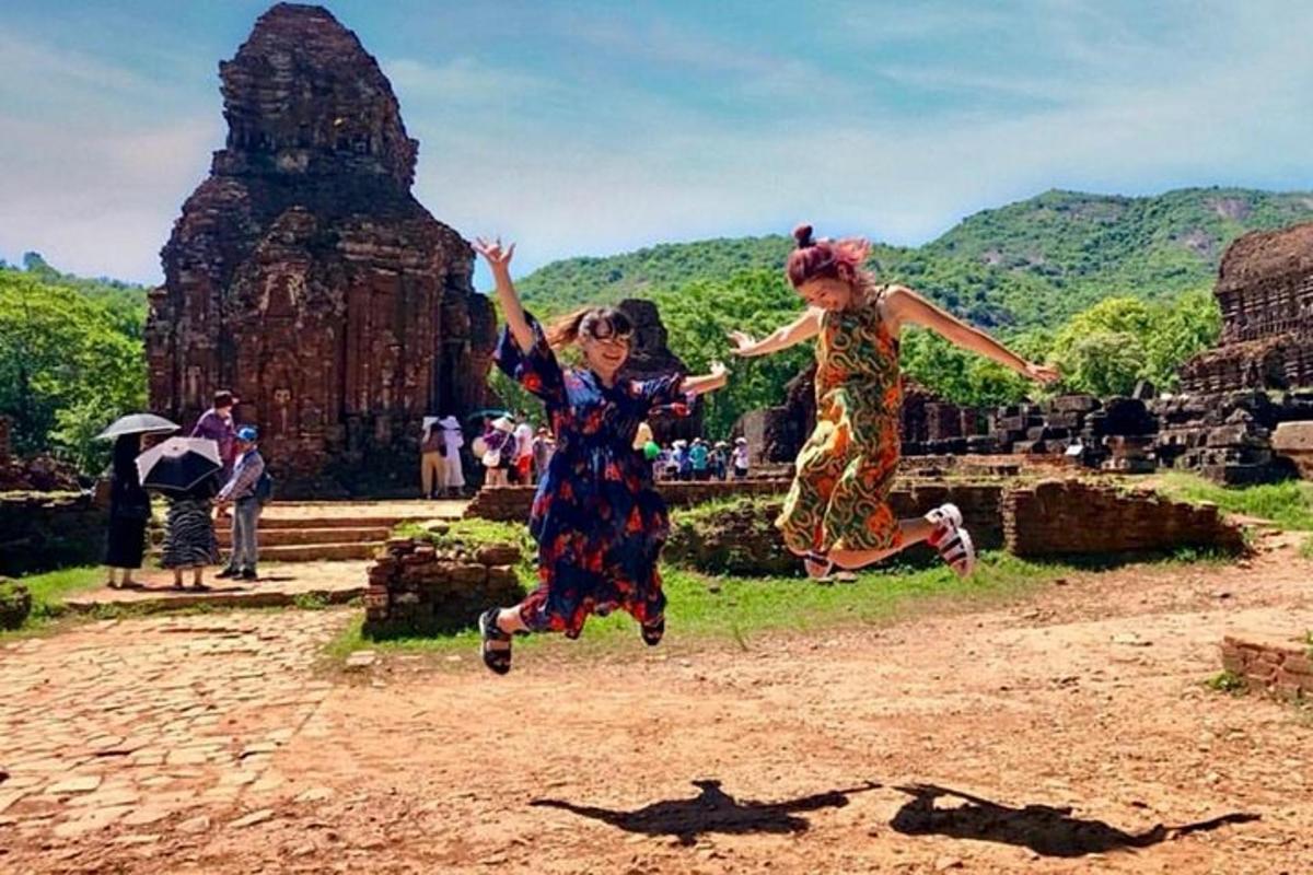 hai cô gái nhảy lên không trung trước một ngôi đền