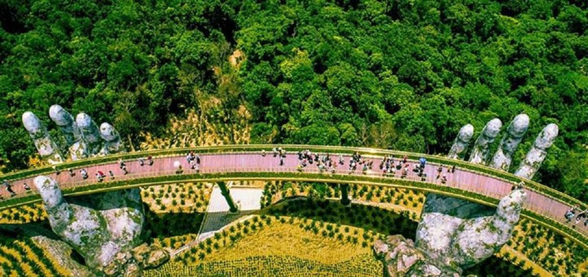 Un grupo de personas caminando por un puente sobre un jardín.