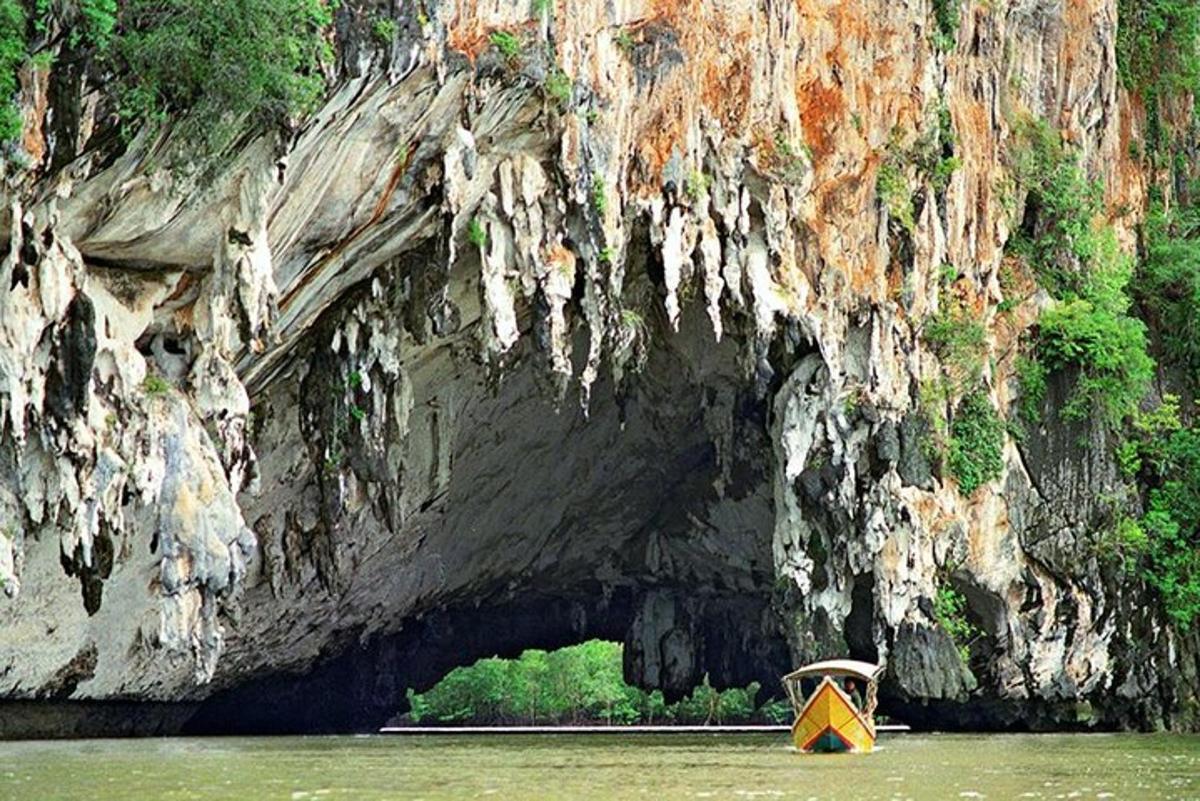 una barca gialla nell'acqua di fronte a una grotta