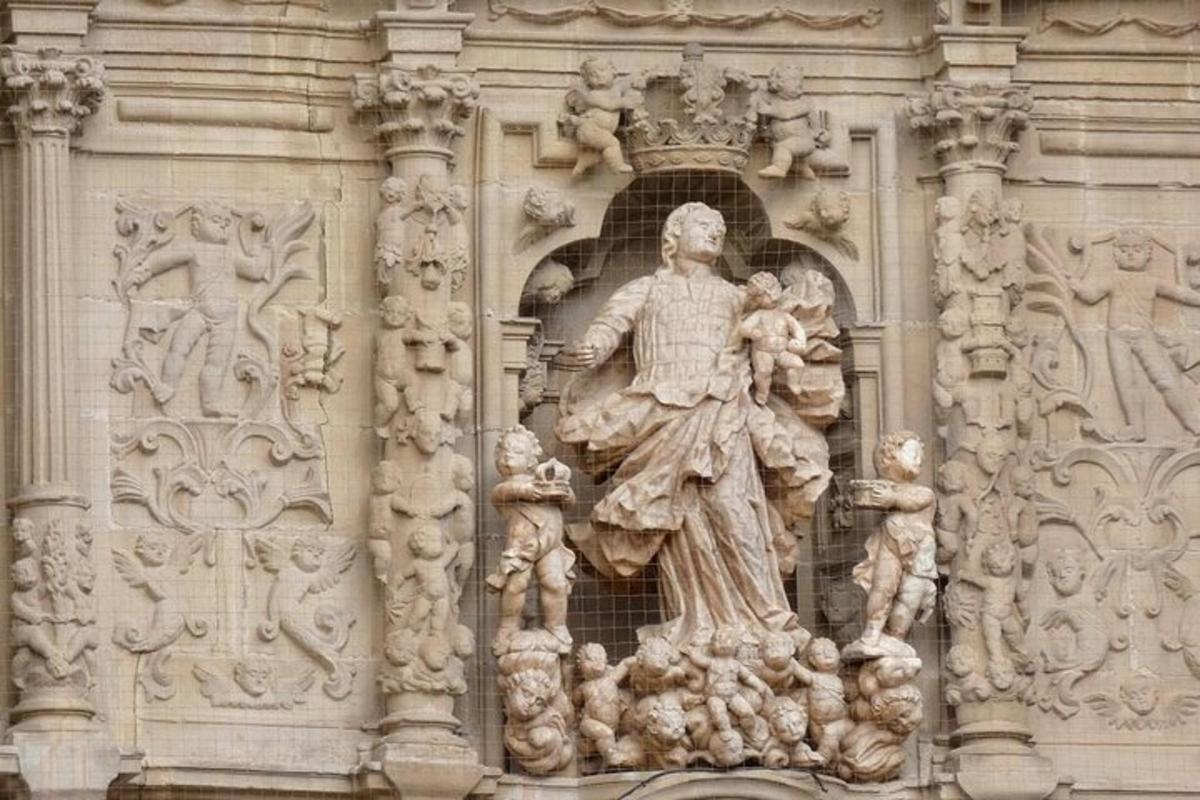 uma estátua de uma mulher na lateral de um prédio