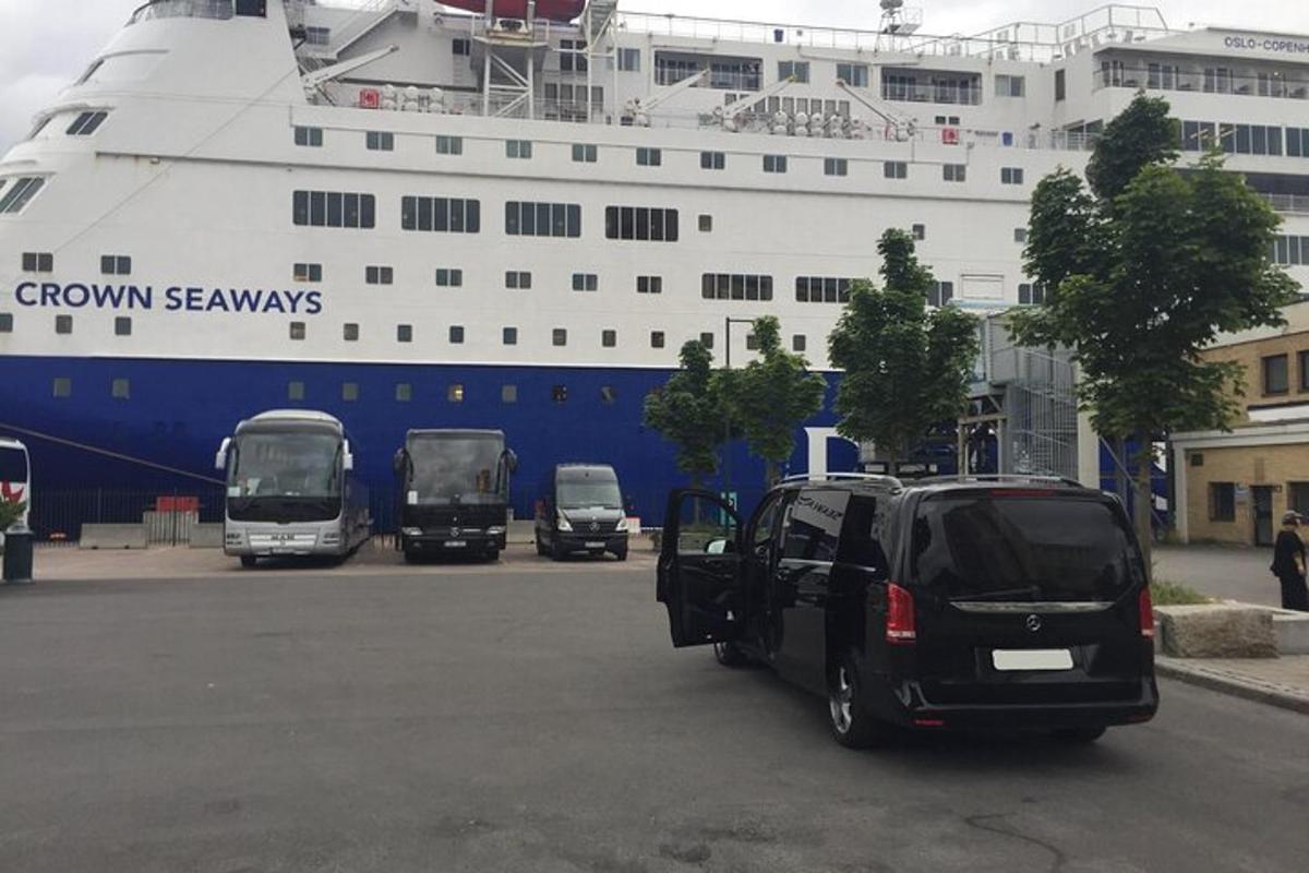 a large cruise ship with cars parked in front of it