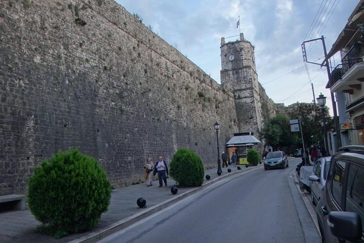 Δύο άνθρωποι περπατούν σε έναν δρόμο δίπλα σε έναν μεγάλο τοίχο