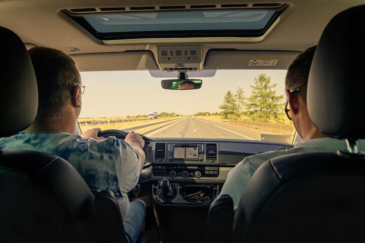 kaks inimest istuvad autos ja vaatavad esiklaasist välja