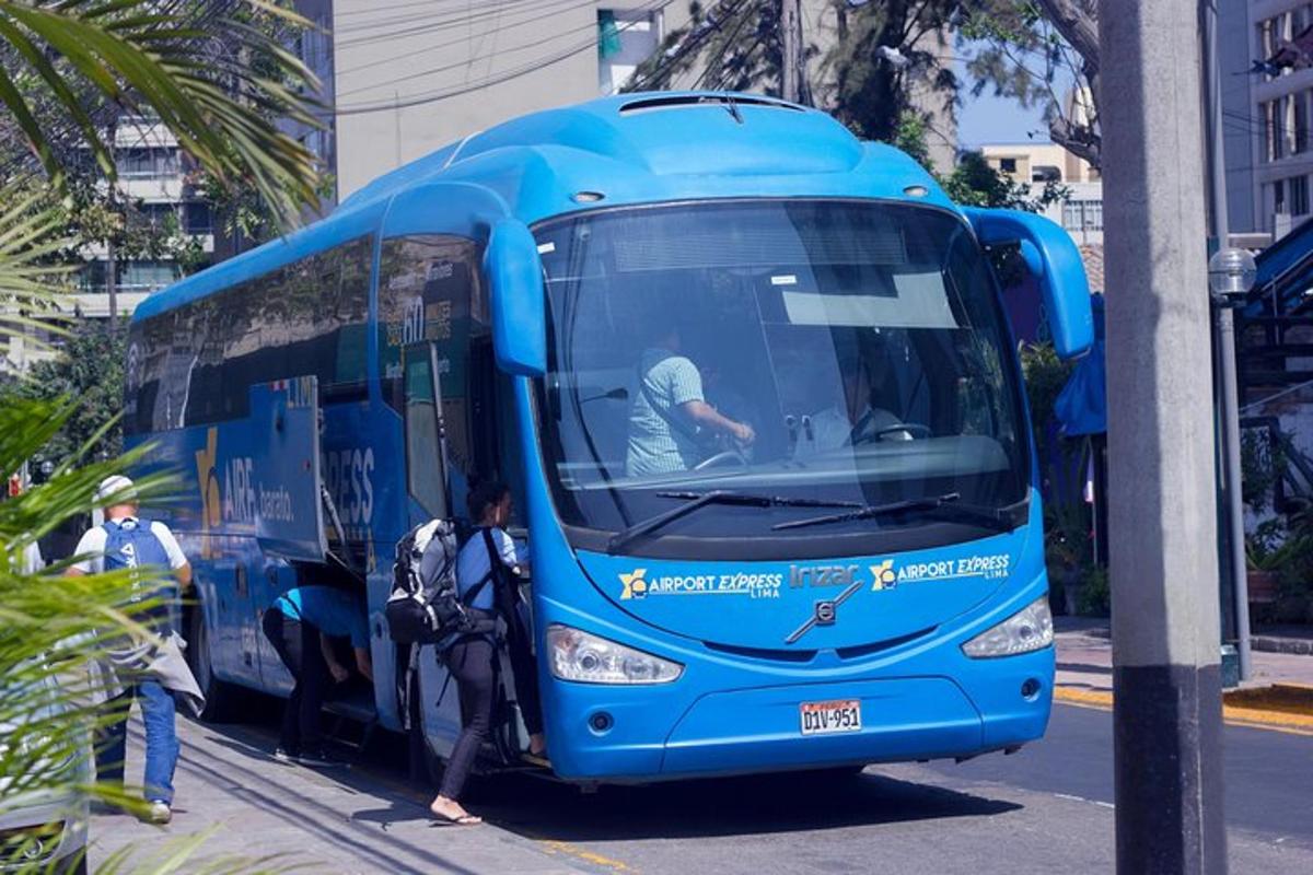 modrý autobus zaparkovaný na ulici s nastupujícími lidmi
