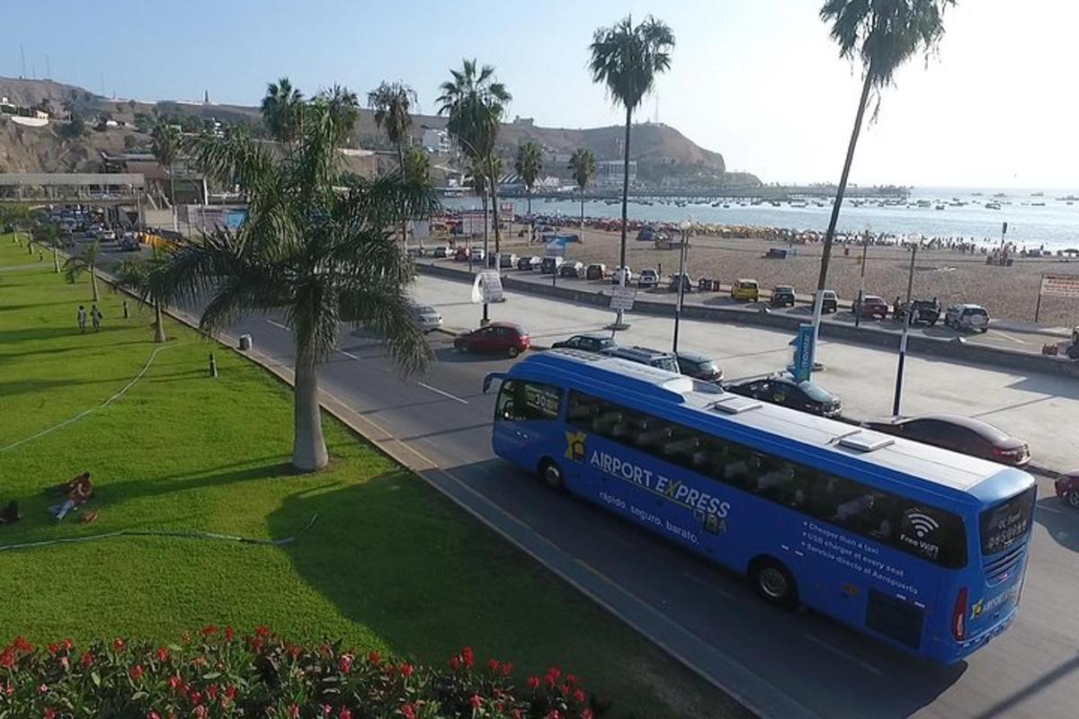modrý autobus jedoucí po ulici vedle pláže