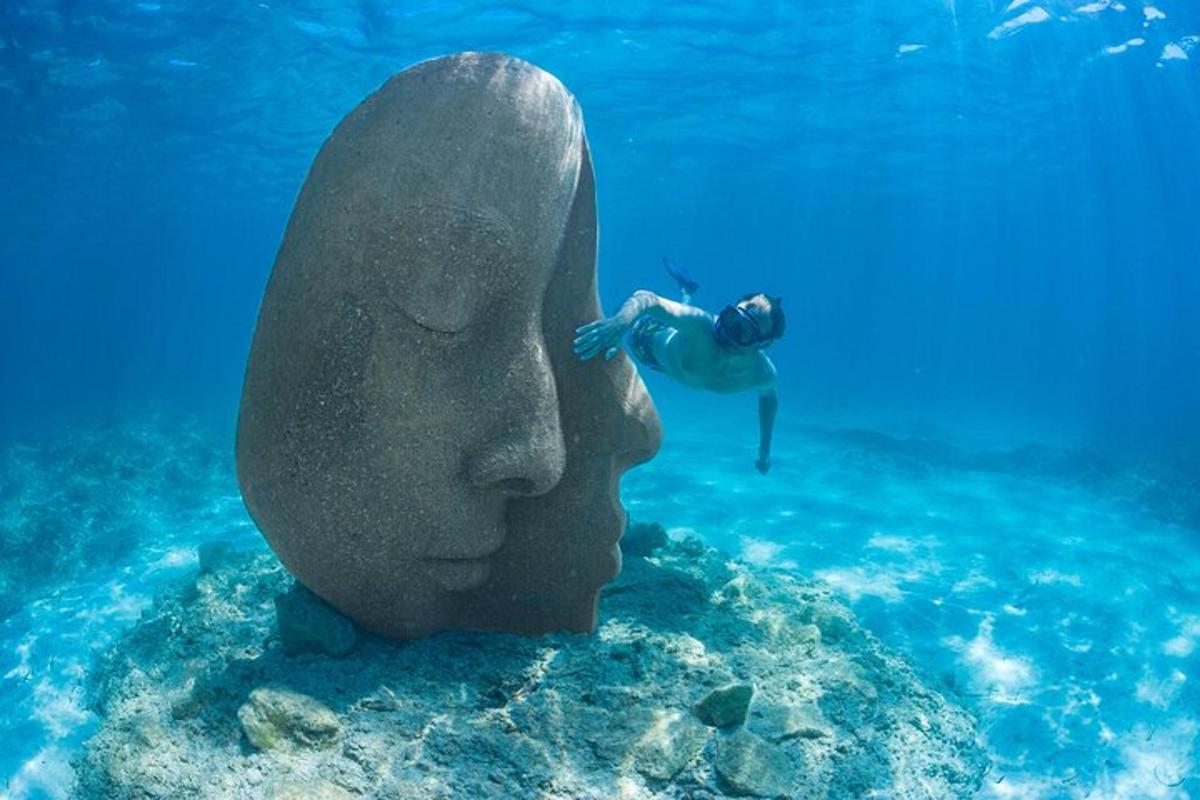 una estàtua d'un cap amb un bussejador a l'aigua