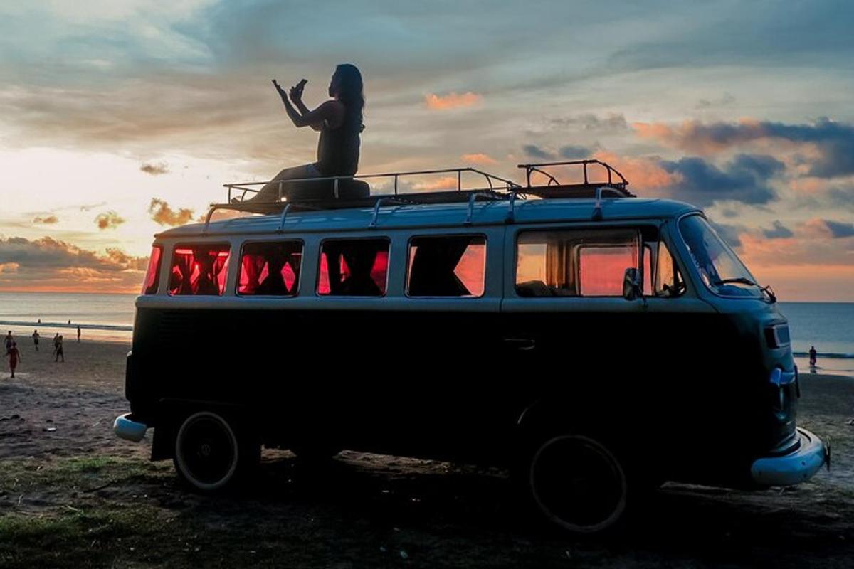 Una camioneta estacionada en la playa con una estatua