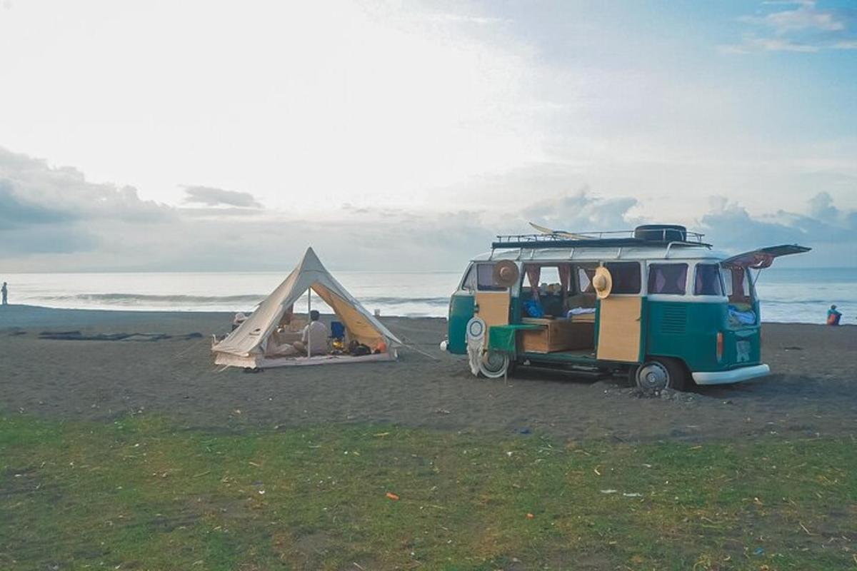 Una camioneta estacionada en la playa con una carpa