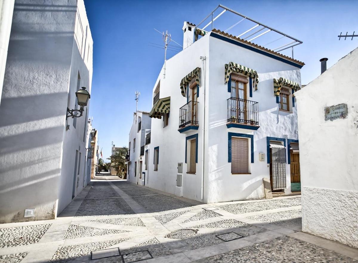 a street with white buildings and a blue sky