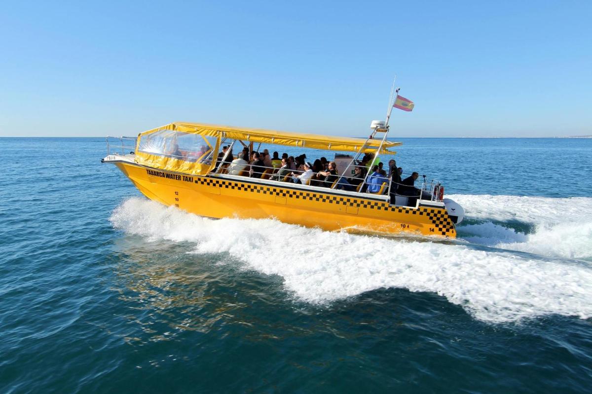 a yellow boat with people on it in the water