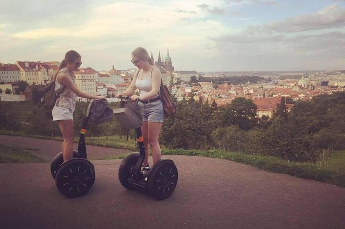 due donne in piedi su uno scooter elettrico che guardano una città
