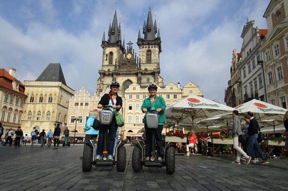 dva lidé jedoucí na onicylkách před budovou