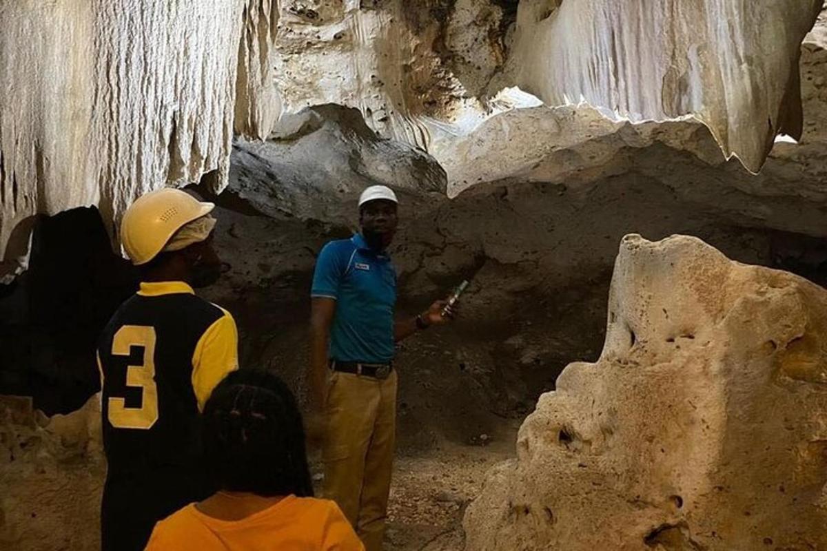Un hombre parado en una cueva con un grupo de personas.