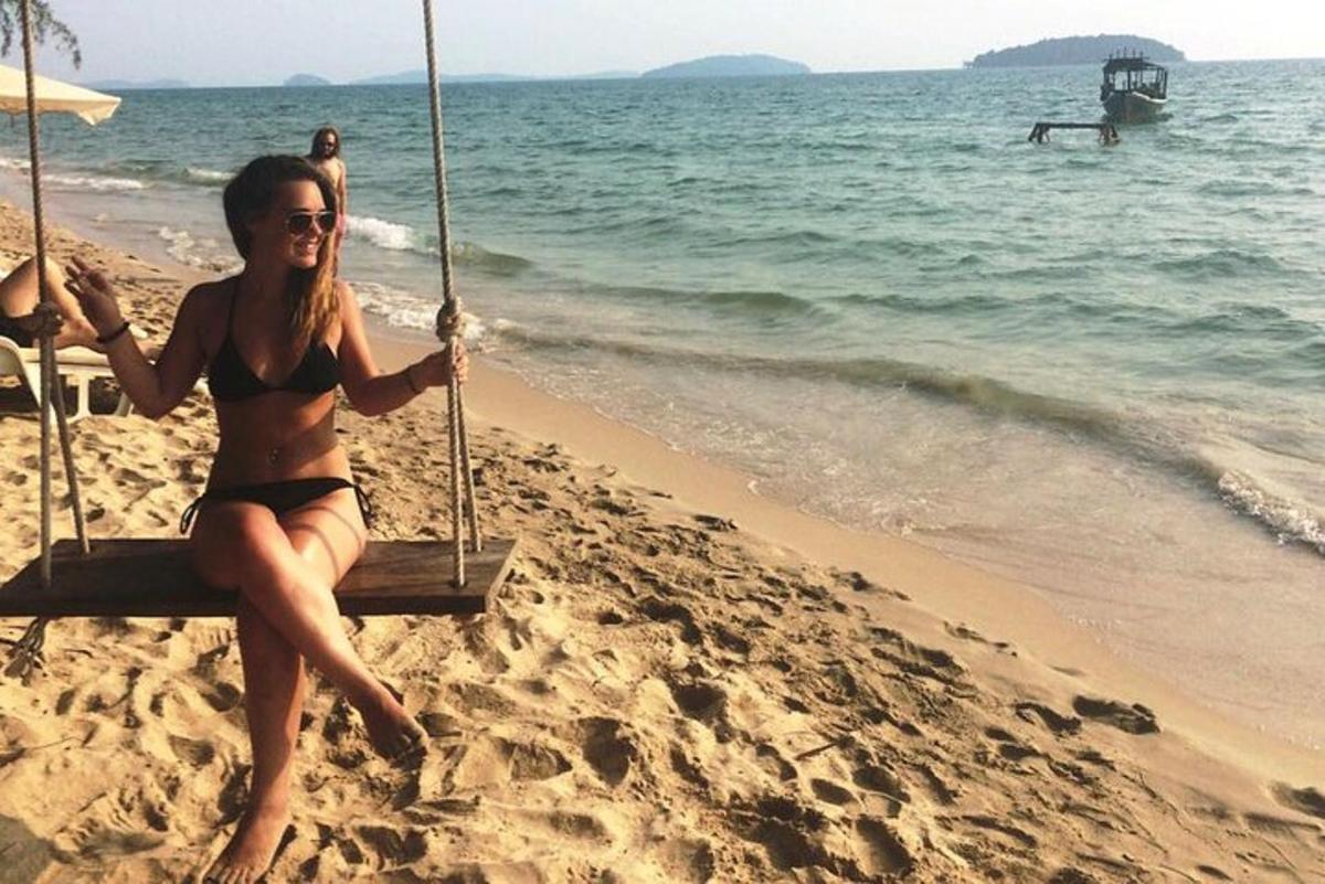 sieviete bikini sēž uz šūpolēm pludmalē